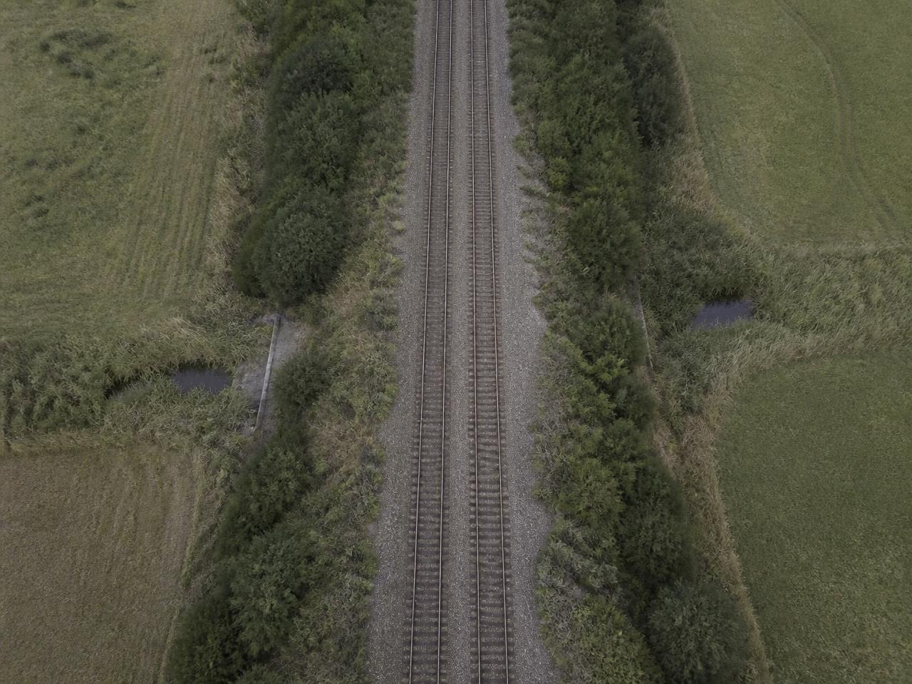 Rail corridor cutting through countryside, seen from above